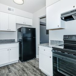 Kitchen with lots of cabinets and black all-electric appliances at Carlson Apartments, located in Colorado Springs, CO