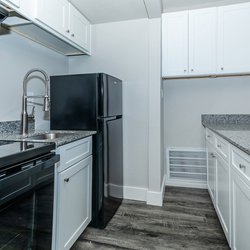 All-electric kitchen with black appliances and white cabinets in one bedroom apartment at Carlson Apartments, located in Colorado Springs, CO