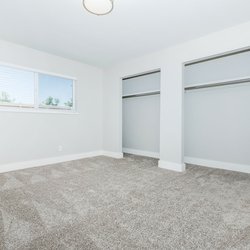 Carpeted primary bedroom with two large losets and ample outlets at Carlson Apartments, located in Colorado Springs, CO