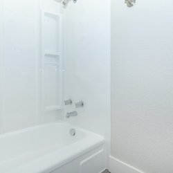 Tub and shower in bathroom at Carlson Apartments, located in Colorado Springs, CO
